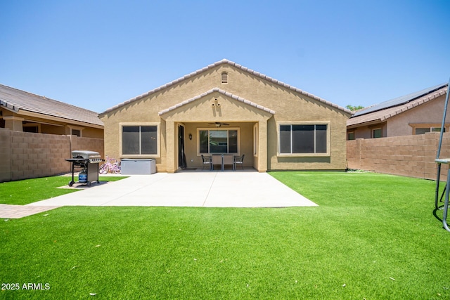 291 E Canyon Rock Rd, San Tan Valley, AZ 85143 - rear view of house featuring a fenced backyard, a ceiling fan, a lawn, a patio, and stucco siding