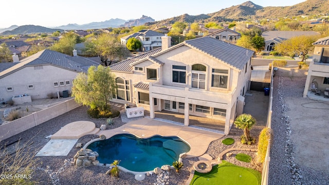 rear view of house with a patio, a fenced backyard, a mountain view, and a residential view