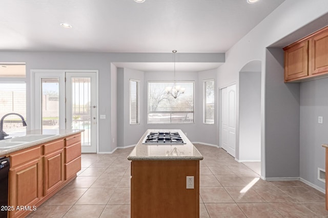 kitchen with a sink, black dishwasher, a center island, light tile patterned flooring, and stainless steel gas cooktop