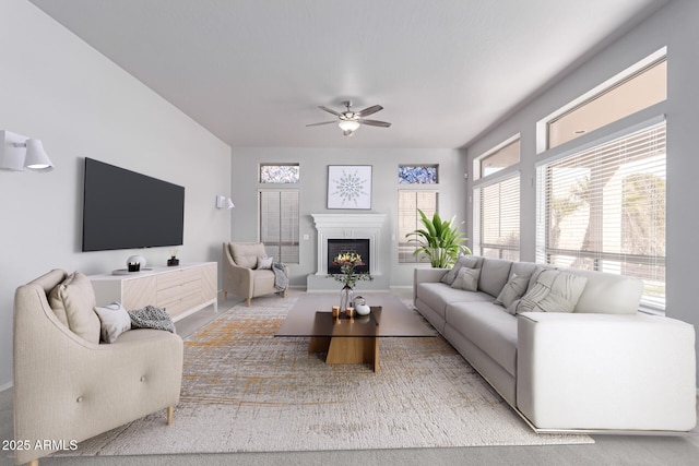 living room with ceiling fan and a lit fireplace