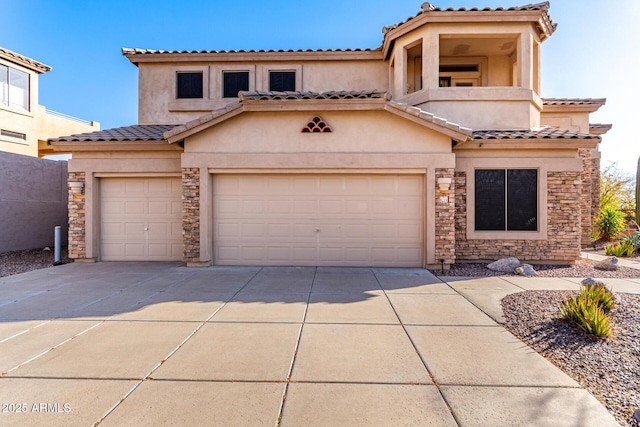 mediterranean / spanish-style home with an attached garage, stucco siding, concrete driveway, stone siding, and a tiled roof