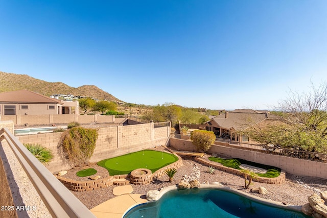 view of swimming pool featuring a fenced in pool, a mountain view, and a fenced backyard