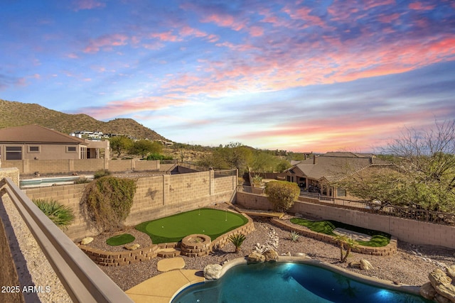 view of swimming pool with a fenced in pool, a mountain view, and a fenced backyard