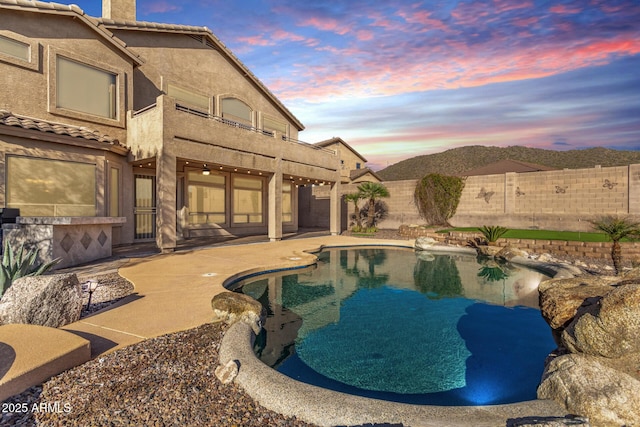 pool at dusk with a fenced in pool, a patio, and a fenced backyard