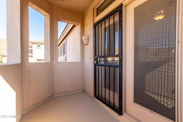 doorway to property with stucco siding and a balcony