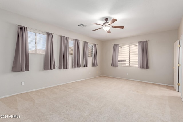 spare room with a ceiling fan, carpet, visible vents, and baseboards