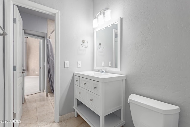 bathroom featuring tile patterned flooring, curtained shower, toilet, a textured wall, and vanity