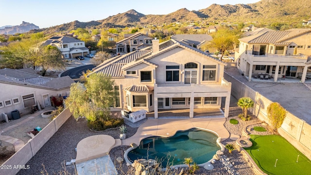 back of property featuring a residential view, a mountain view, a patio, and a fenced backyard