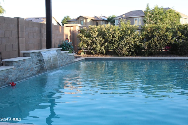 view of swimming pool with pool water feature