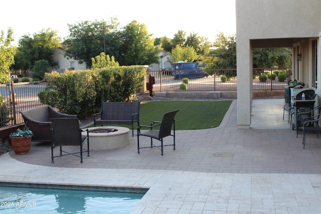 view of patio / terrace featuring an outdoor fire pit and a fenced in pool