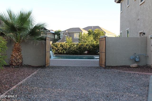 view of gate featuring pool water feature and a fenced in pool