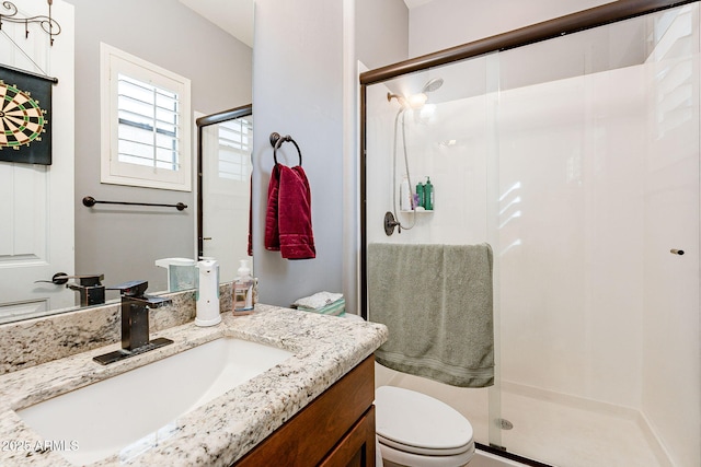 bathroom featuring toilet, walk in shower, and vanity