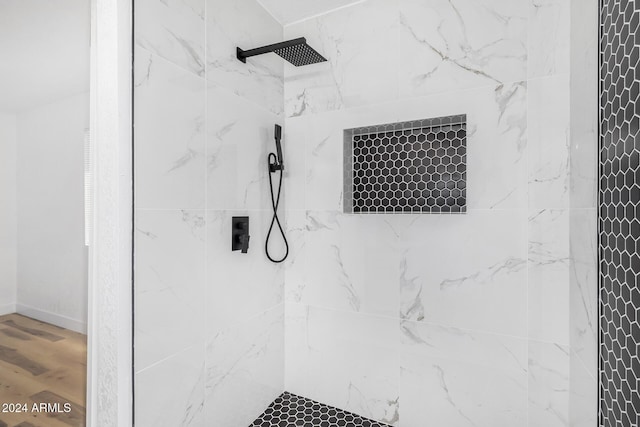 details with a tile shower and wood-type flooring