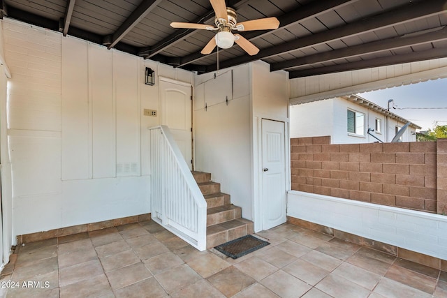 stairs featuring tile patterned floors, ceiling fan, beam ceiling, and wooden ceiling