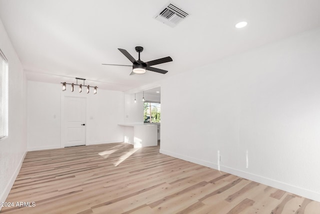 spare room featuring ceiling fan, rail lighting, and light hardwood / wood-style flooring