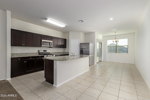 kitchen featuring pendant lighting, a chandelier, a kitchen island with sink, dark brown cabinets, and appliances with stainless steel finishes