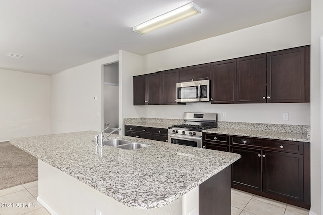 kitchen featuring dark brown cabinets, sink, an island with sink, and stainless steel appliances