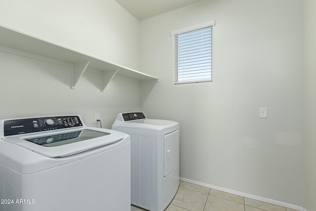 clothes washing area with washing machine and dryer and light tile patterned floors