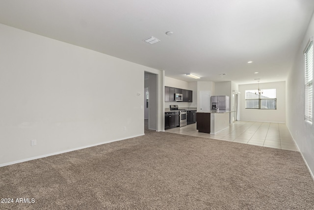 unfurnished living room with an inviting chandelier and light colored carpet