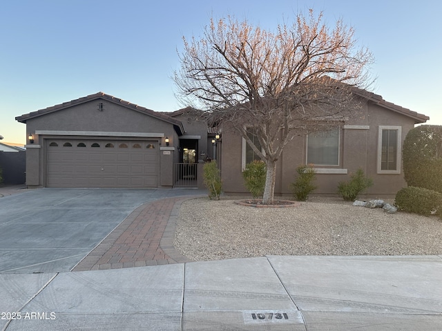 single story home featuring an attached garage, driveway, a tile roof, and stucco siding