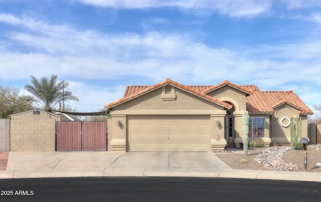 mediterranean / spanish-style house with a garage, concrete driveway, a tiled roof, a gate, and stucco siding