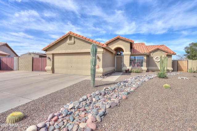 mediterranean / spanish home with stucco siding, concrete driveway, fence, a garage, and a tiled roof