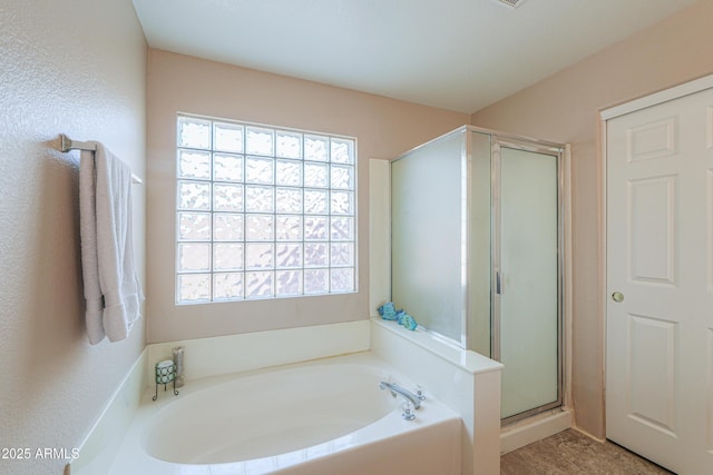 full bathroom featuring a stall shower and a bath