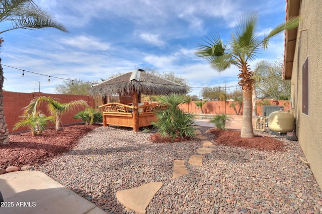 view of yard with a gazebo, a fenced backyard, and a wooden deck