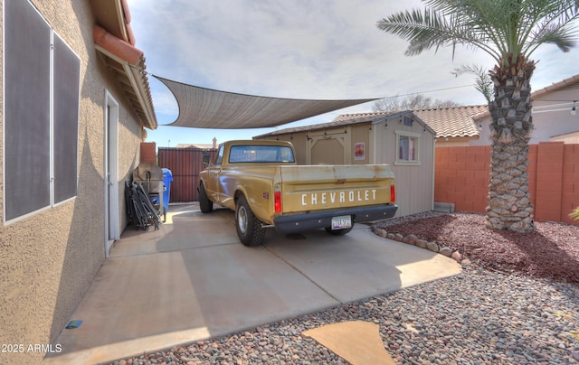 view of parking with a carport and fence