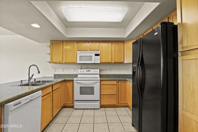 kitchen featuring sink, light tile patterned floors, a tray ceiling, kitchen peninsula, and white appliances