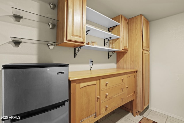 kitchen featuring light tile patterned floors, stainless steel fridge, and butcher block countertops