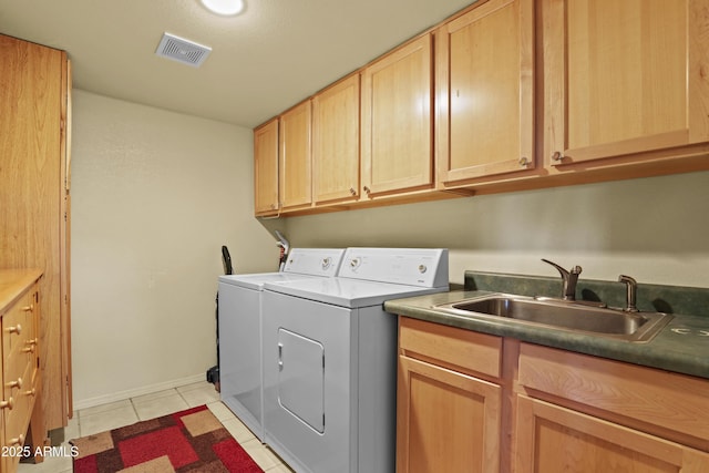 clothes washing area featuring sink, light tile patterned floors, washer and clothes dryer, and cabinets