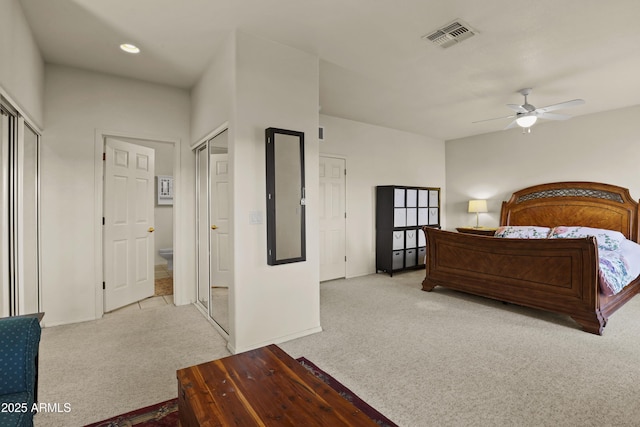 carpeted bedroom featuring multiple closets and ceiling fan