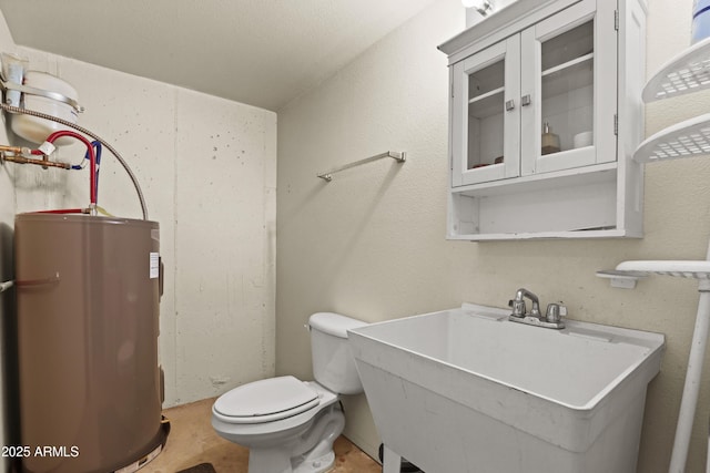 bathroom with sink, electric water heater, and toilet