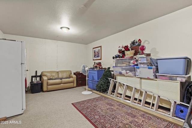 interior space with white fridge, carpet, and a textured ceiling