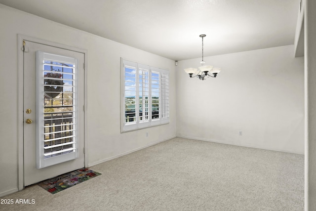 unfurnished dining area featuring carpet and a chandelier