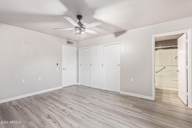 unfurnished bedroom with a closet, visible vents, light wood-style flooring, and baseboards