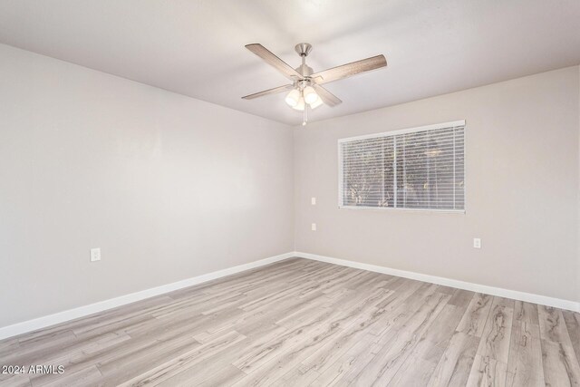 unfurnished room featuring baseboards, light wood finished floors, and ceiling fan