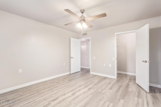 unfurnished bedroom with light wood finished floors, visible vents, ceiling fan, and baseboards