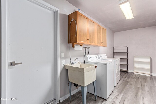 laundry area with baseboards, cabinet space, independent washer and dryer, and light wood-type flooring