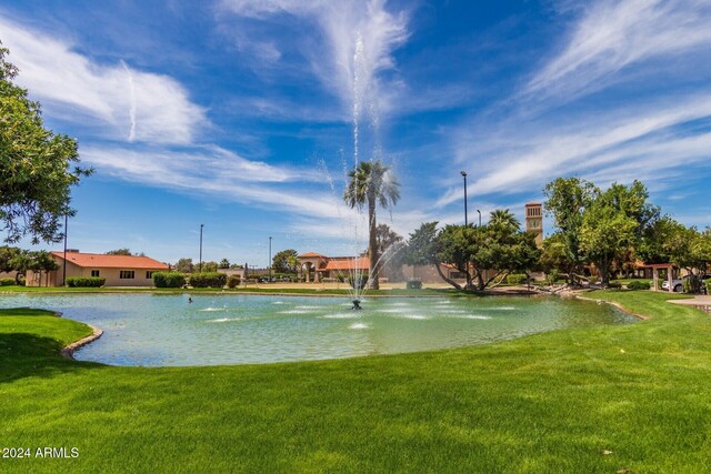 view of home's community with a lawn and a water view