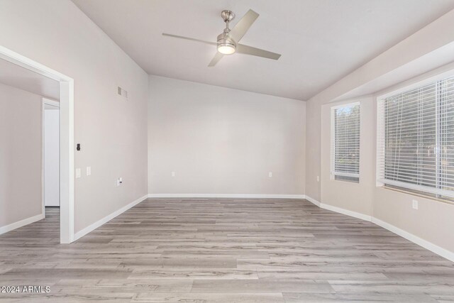 unfurnished room featuring visible vents, ceiling fan, vaulted ceiling, and light wood finished floors