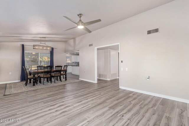 dining space with wood finished floors, baseboards, visible vents, lofted ceiling, and ceiling fan