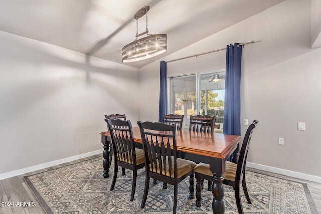 dining area featuring lofted ceiling, wood finished floors, and baseboards