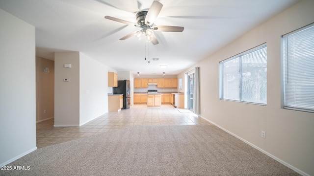 unfurnished living room with ceiling fan and light tile patterned flooring