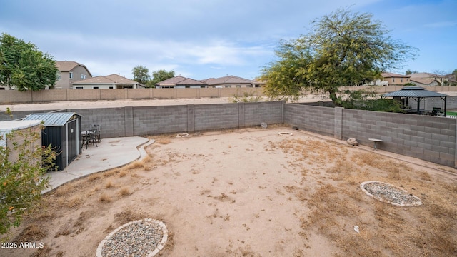 view of yard featuring a gazebo, a patio, and a storage unit