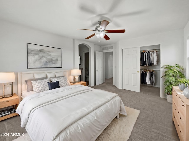 bedroom with dark carpet, ceiling fan, and a closet