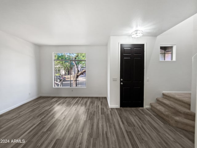 entryway with an inviting chandelier and dark wood-type flooring