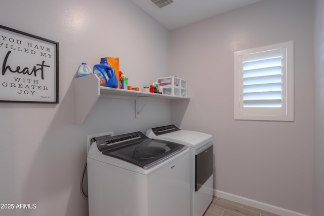 washroom featuring baseboards, laundry area, and washing machine and clothes dryer