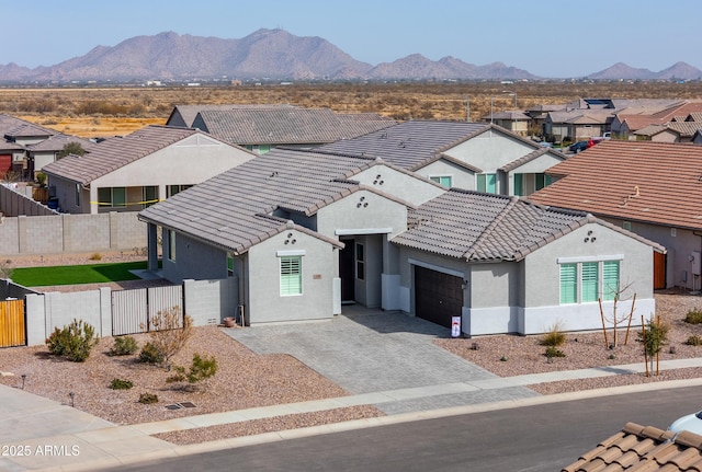 view of front of house featuring a tile roof, fence private yard, a garage, and stucco siding